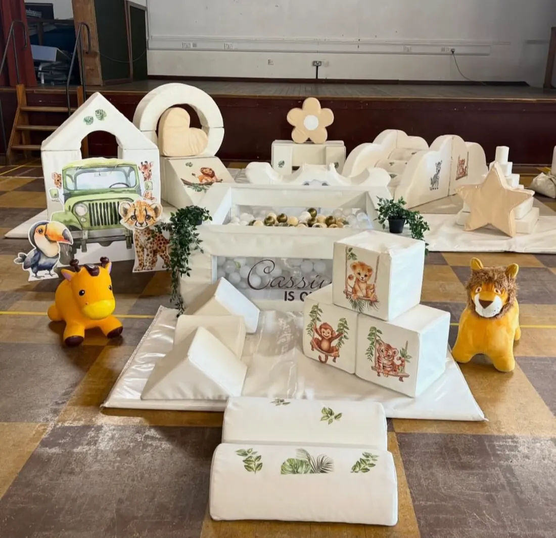 Safari-themed white soft play with jungle animals and ride-on toys
